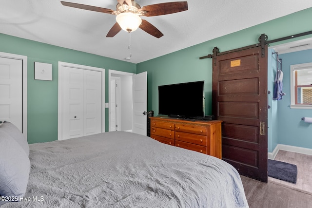 205 Sand Dollar Ln, Hampstead, NC 28443 - bedroom with wood finished floors, a barn door, baseboards, and a ceiling fan