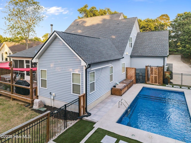 708 Cordgrass Rd, Hampstead, NC 28443 - rear view of house featuring a shingled roof, a fenced backyard, a deck, a sunroom, and a patio