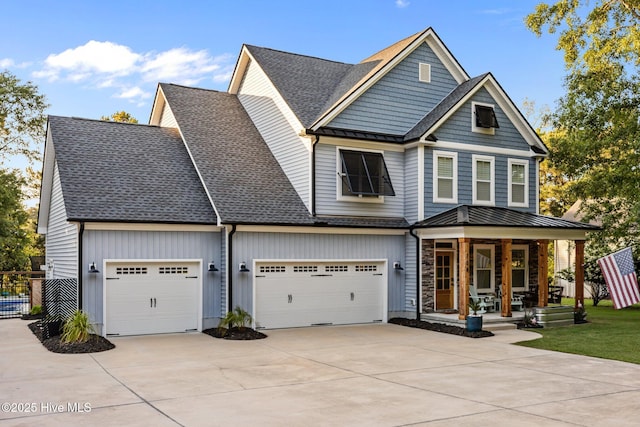 708 Cordgrass Rd, Hampstead, NC 28443 - view of front facade with covered porch, a standing seam roof, concrete driveway, roof with shingles, and metal roof