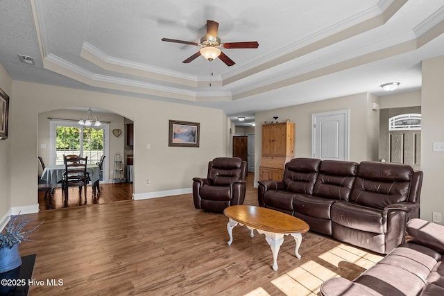 606 Spoleto Ct, Swansboro, NC 28584 - living area with a tray ceiling, arched walkways, a chandelier, wood finished floors, and crown molding