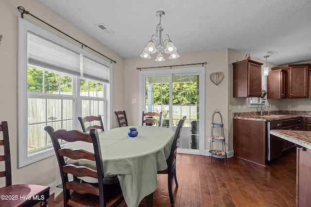 606 Spoleto Ct, Swansboro, NC 28584 - dining area with dark wood-style floors, a chandelier, baseboards, and a textured ceiling