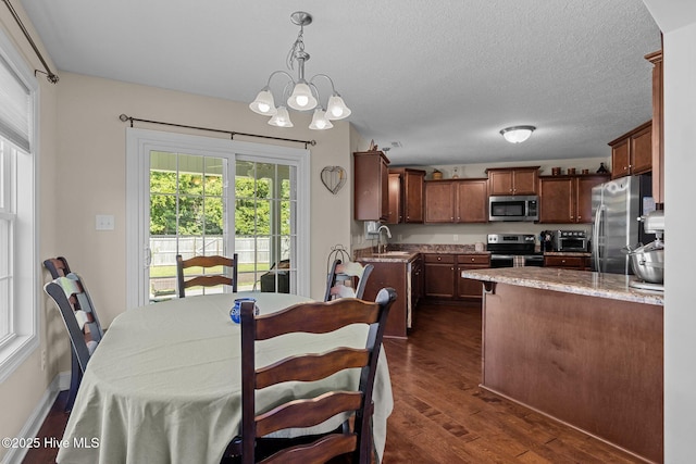 606 Spoleto Ct, Swansboro, NC 28584 - dining room featuring healthy amount of natural light, dark wood-style floors, a chandelier, and a textured ceiling