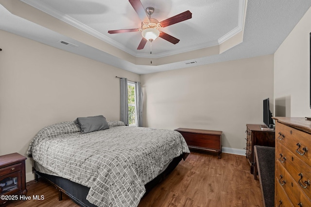 606 Spoleto Ct, Swansboro, NC 28584 - bedroom with a raised ceiling, wood finished floors, ornamental molding, baseboards, and a ceiling fan
