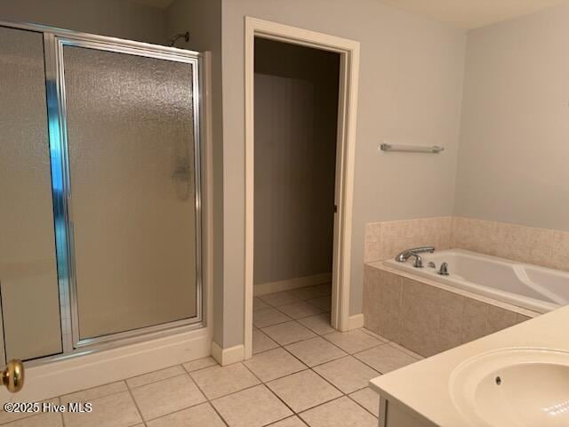 full bathroom featuring tile patterned flooring, a stall shower, a bath, and vanity