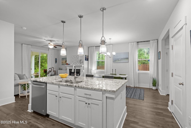 kitchen featuring a sink, dishwasher, baseboards, and open floor plan
