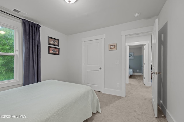 bedroom with light carpet and baseboards