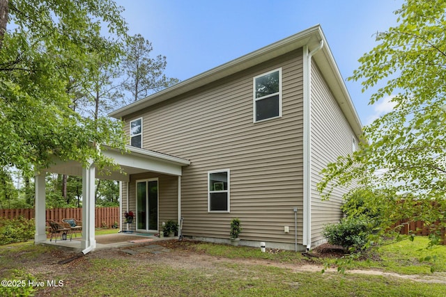 rear view of property featuring a patio area and fence