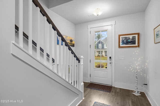 foyer featuring wood finished floors, stairs, and baseboards