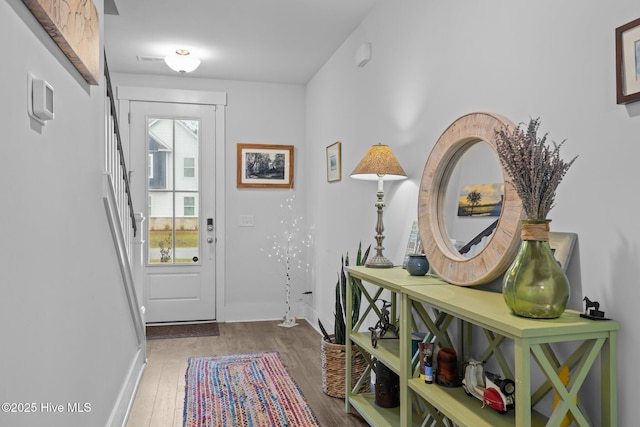 doorway with wood finished floors and baseboards