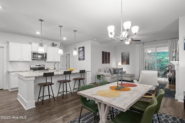 dining space featuring dark wood finished floors, a chandelier, and recessed lighting