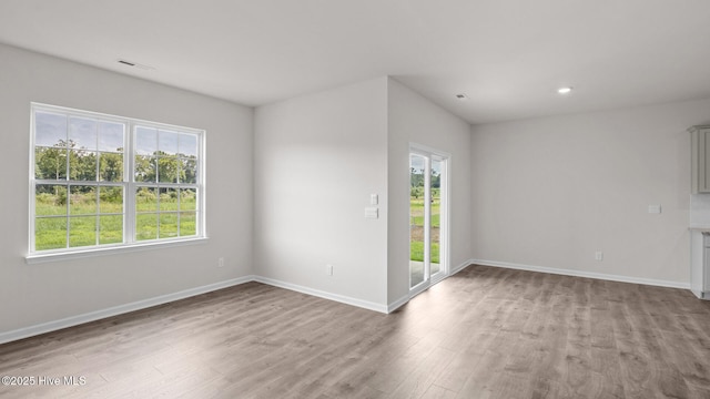 spare room featuring wood finished floors, baseboards, and recessed lighting