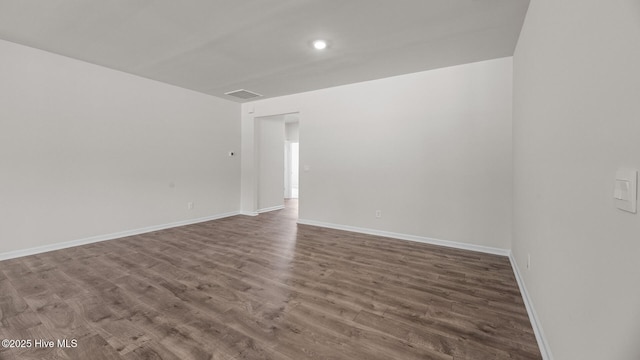 empty room with wood finished floors, baseboards, and recessed lighting