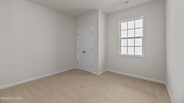 empty room featuring carpet, baseboards, and healthy amount of natural light