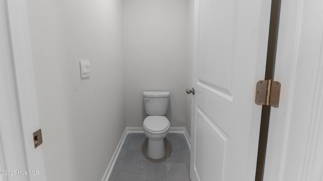 bathroom featuring baseboards, toilet, and tile patterned floors