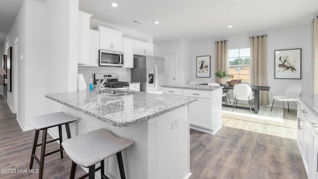 2020 Minnette Cir, New Bern, NC 28562 - kitchen with appliances with stainless steel finishes, a center island, dark wood finished floors, recessed lighting, and white cabinetry