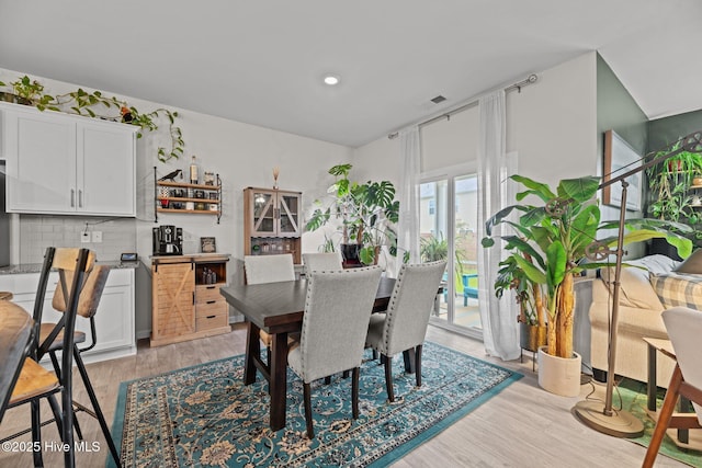 dining space with light wood finished floors and recessed lighting