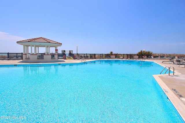 community pool featuring a gazebo, fence, and a patio