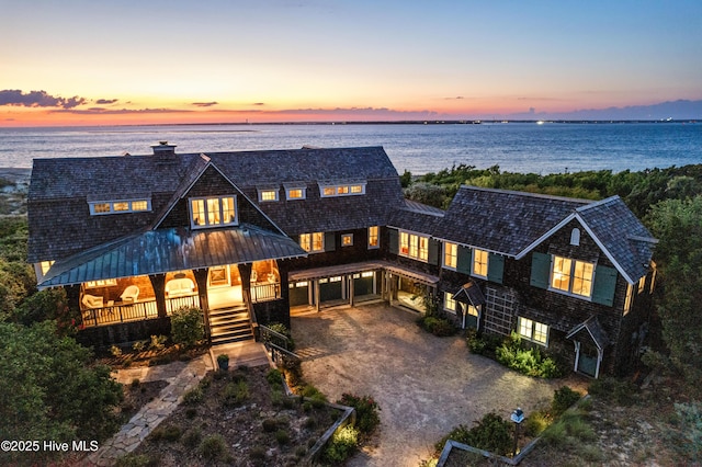 21 Sea Gull Trl, Bald Head Island, NC 28461 - view of front of house with driveway, a chimney, a water view, and a porch