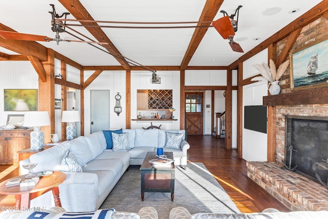 21 Sea Gull Trl, Bald Head Island, NC 28461 - living room featuring dark wood-style flooring, beamed ceiling, a brick fireplace, and wooden walls