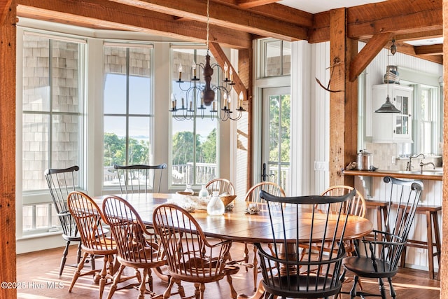 21 Sea Gull Trl, Bald Head Island, NC 28461 - dining space featuring wood finished floors, a chandelier, and beamed ceiling