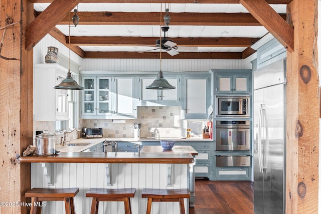 21 Sea Gull Trl, Bald Head Island, NC 28461 - kitchen with built in appliances, a warming drawer, a sink, beamed ceiling, and a peninsula