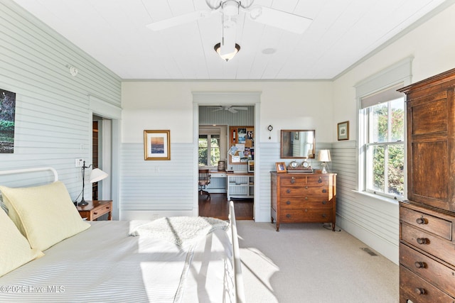 21 Sea Gull Trl, Bald Head Island, NC 28461 - bedroom with multiple windows, wood walls, light colored carpet, and a wainscoted wall