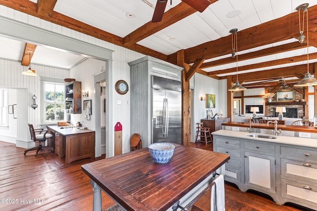 21 Sea Gull Trl, Bald Head Island, NC 28461 - dining room with dark wood-style flooring, beam ceiling, a fireplace, a ceiling fan, and wooden walls