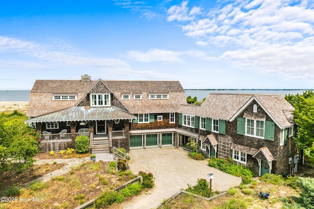 21 Sea Gull Trl, Bald Head Island, NC 28461 - shingle-style home featuring covered porch, a chimney, a water view, and driveway