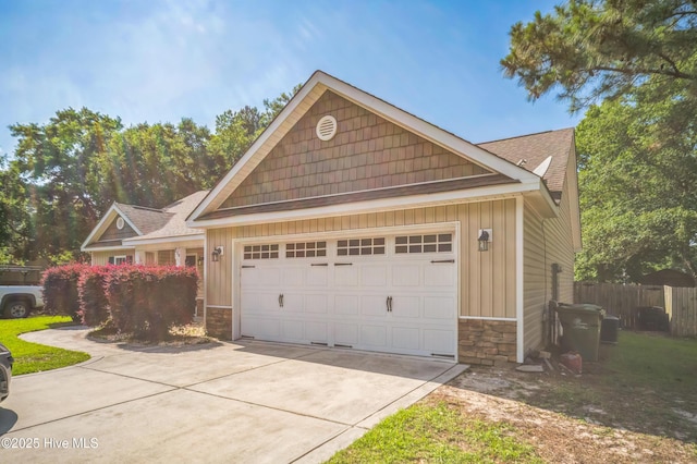 239 Shellbank Dr, Sneads Ferry, NC 28460 - view of front facade featuring stone siding, concrete driveway, a garage, and board and batten siding