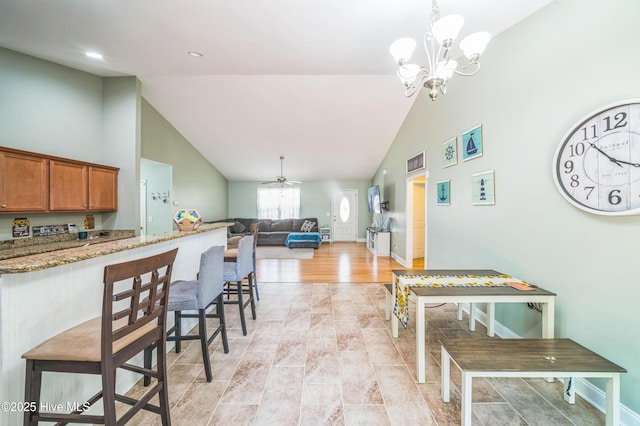 239 Shellbank Dr, Sneads Ferry, NC 28460 - kitchen featuring high vaulted ceiling, brown cabinetry, light stone countertops, ceiling fan, and decorative light fixtures