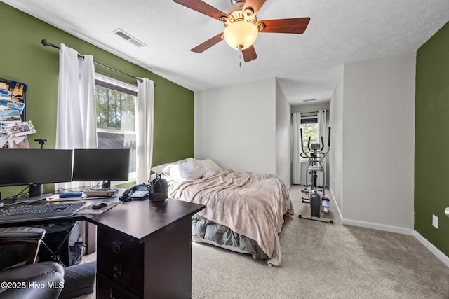 carpeted bedroom with a desk, baseboards, and a ceiling fan