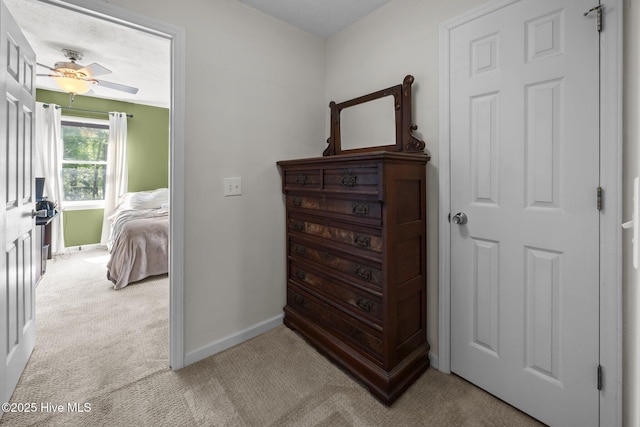 bedroom featuring light carpet, baseboards, and a ceiling fan