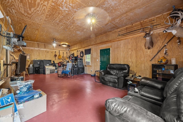 living room featuring finished concrete floors, wooden walls, and a garage