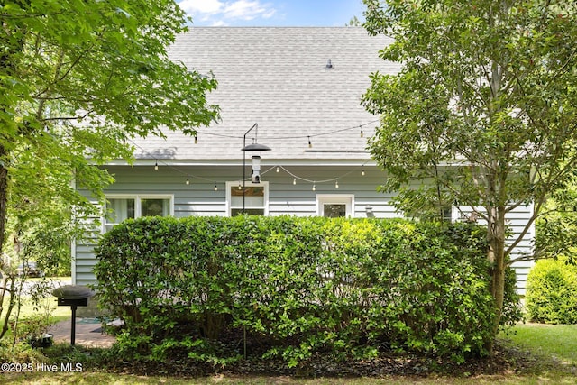 rear view of house with a shingled roof