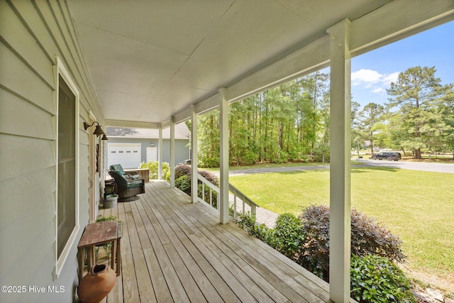 deck featuring covered porch and a yard