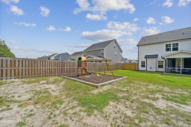 view of yard featuring a playground, a sunroom, and a residential view