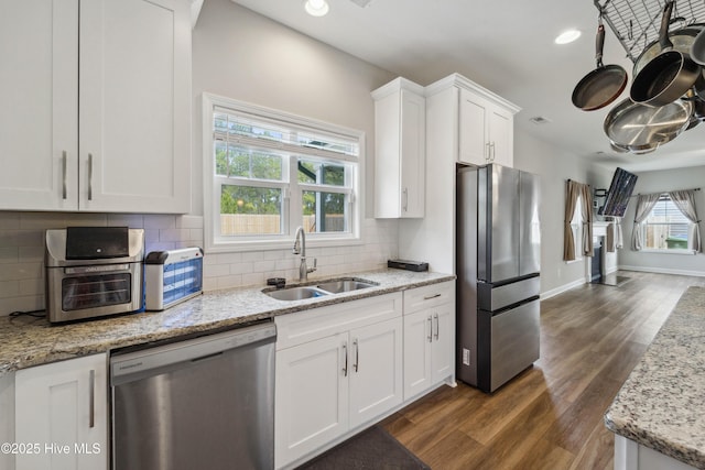 kitchen with stainless steel appliances, a sink, white cabinetry, dark wood finished floors, and recessed lighting