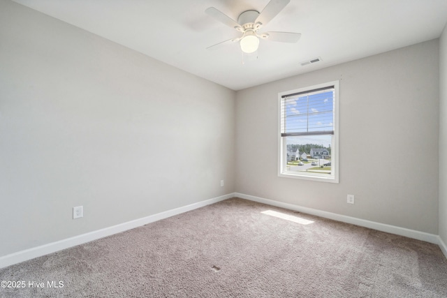 empty room with carpet flooring, baseboards, and a ceiling fan