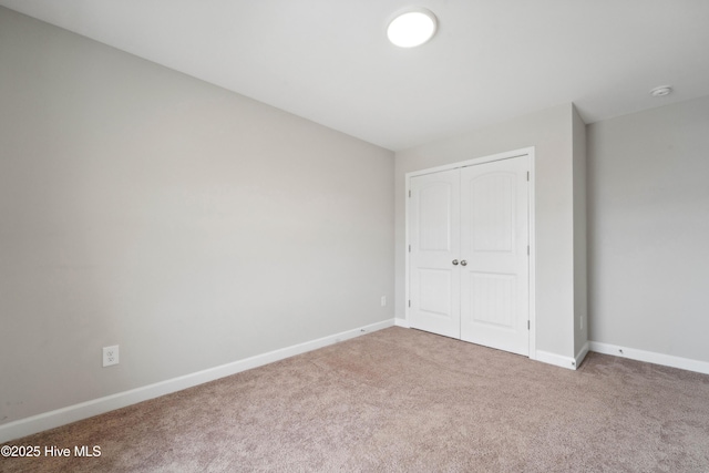 unfurnished bedroom with carpet, baseboards, and a closet