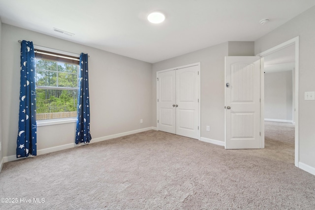 unfurnished bedroom featuring carpet flooring, baseboards, and a closet