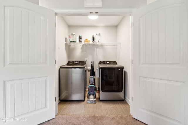 laundry area featuring washing machine and dryer, carpet, and baseboards
