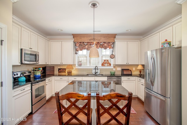 301 Hedrick St, Beaufort, NC 28516 - kitchen featuring appliances with stainless steel finishes, a sink, dark wood-type flooring, crown molding, and decorative light fixtures