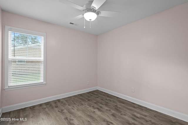 spare room with baseboards, wood finished floors, and ceiling fan