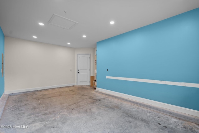 spare room featuring recessed lighting, concrete floors, attic access, and baseboards
