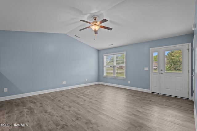 unfurnished living room featuring ceiling fan, vaulted ceiling, wood finished floors, and baseboards