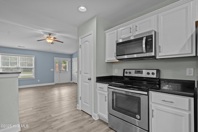 kitchen featuring stainless steel appliances, white cabinetry, ceiling fan, baseboards, and light wood-style floors