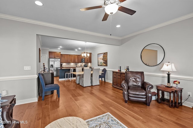 living room with light wood finished floors, a ceiling fan, recessed lighting, ornamental molding, and baseboards
