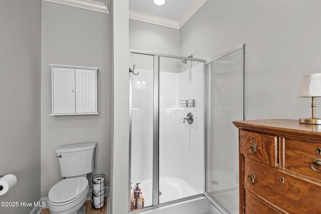 bathroom with ornamental molding, a stall shower, and toilet