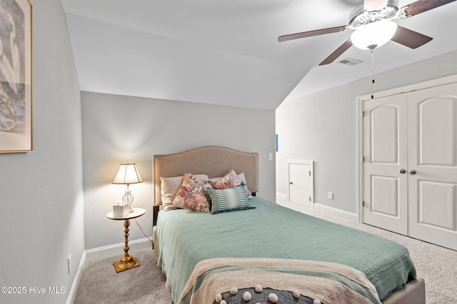 bedroom featuring carpet flooring, baseboards, vaulted ceiling, a closet, and a ceiling fan