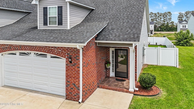 view of exterior entry featuring roof with shingles, brick siding, concrete driveway, and a garage
